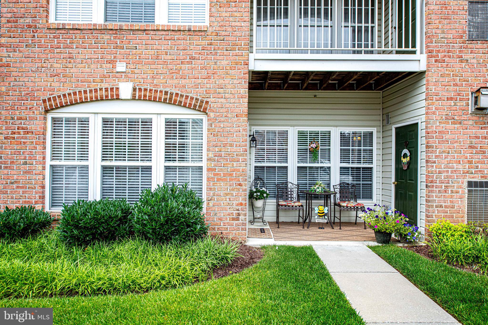 9506 Amberleigh Lane, Unit 9506A Perry Hall, MD 21128 - Photo 5 of 33 a front view of a house with a garden and outdoor seating