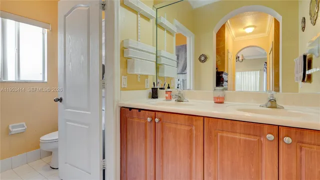 a bathroom with a double vanity sink toilet and a mirror