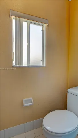 a white toilet sitting next to a window