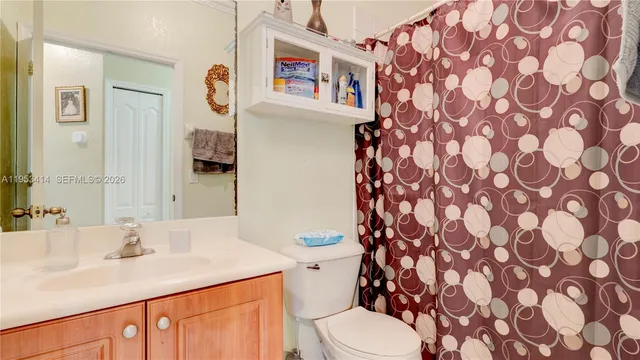 a bathroom with a sink a toilet and shower curtain