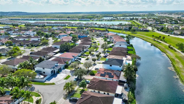 an aerial view of residential houses with outdoor space and lake view