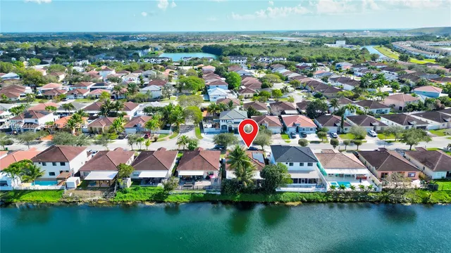 an aerial view of residential houses with outdoor space and lake view