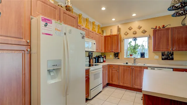 a kitchen with a sink a refrigerator and cabinets