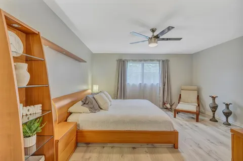 a bedroom with a bed and wooden floor