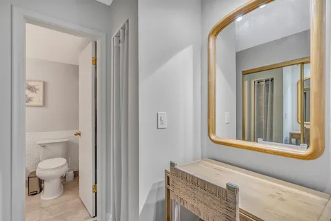 a bathroom with a toilet sink and mirror