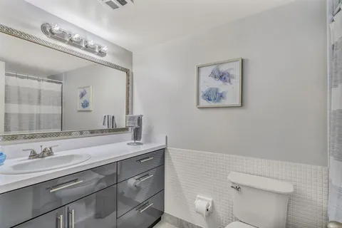 a bathroom with a sink a toilet and a mirror