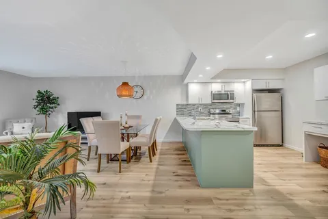 a living room with furniture a dining table and chairs with kitchen view