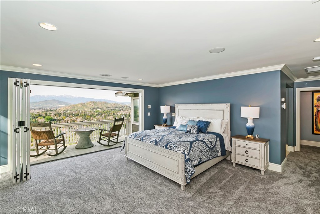 3124 Pachappa Drive Riverside, CA 92506 - Photo 30 of 50 a spacious bedroom with a bed and large mirror next to a large window