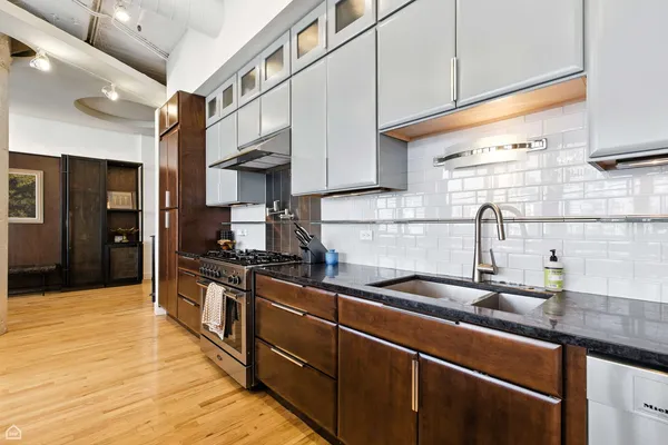 a kitchen with stainless steel appliances granite countertop a sink and a stove