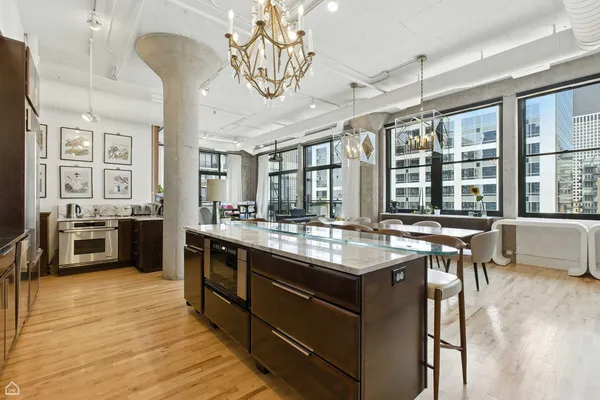 a kitchen with stainless steel appliances granite countertop a stove and chairs