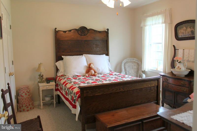 1138 Clark Road Middletown, VA 22645 - Photo 22 of 30 a bed sitting in a bedroom next to a window with tv