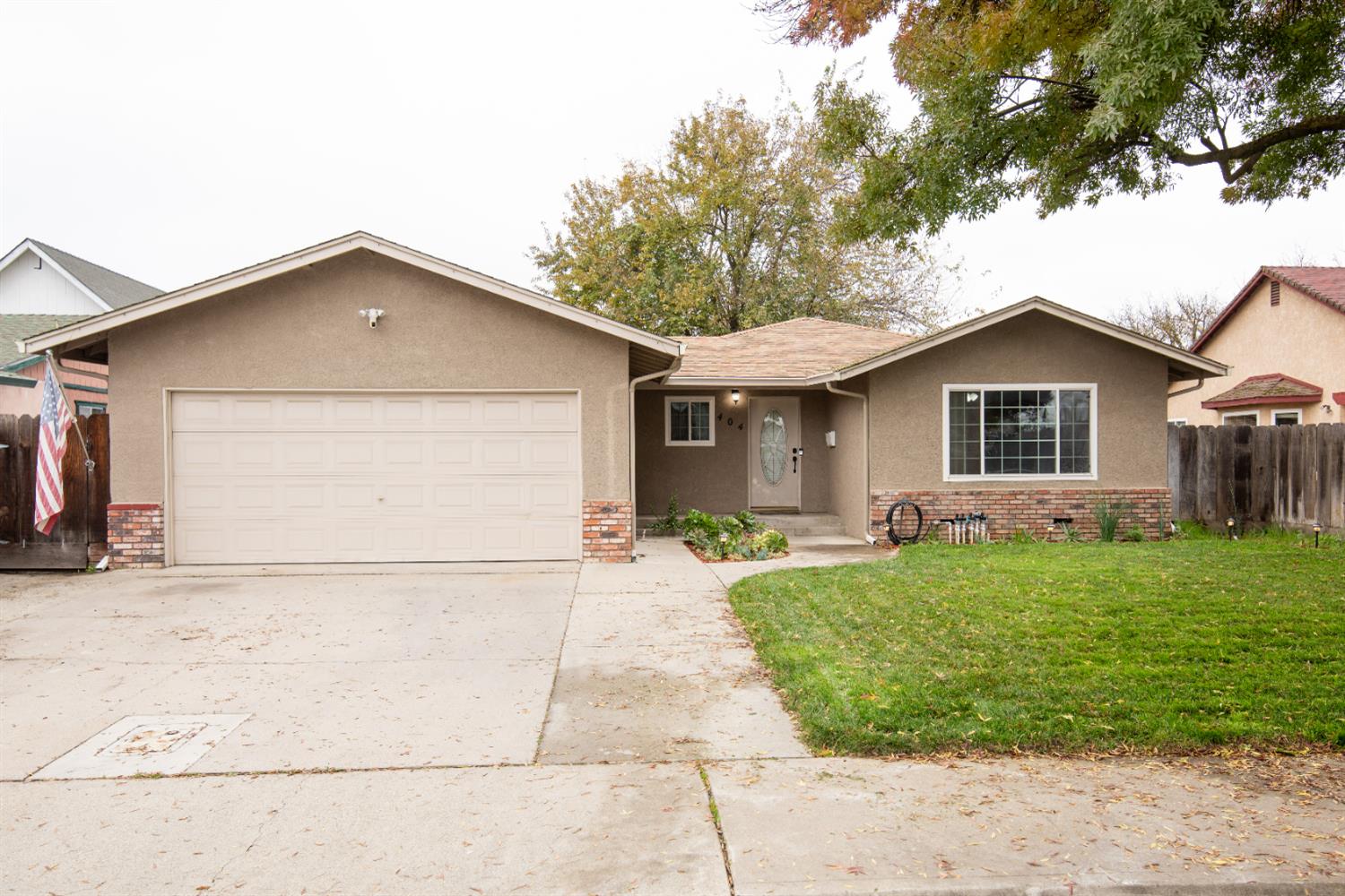 404 Trask Lane Modesto, CA 95354 - Photo 1 of 25 a front view of a house with a garden and yard