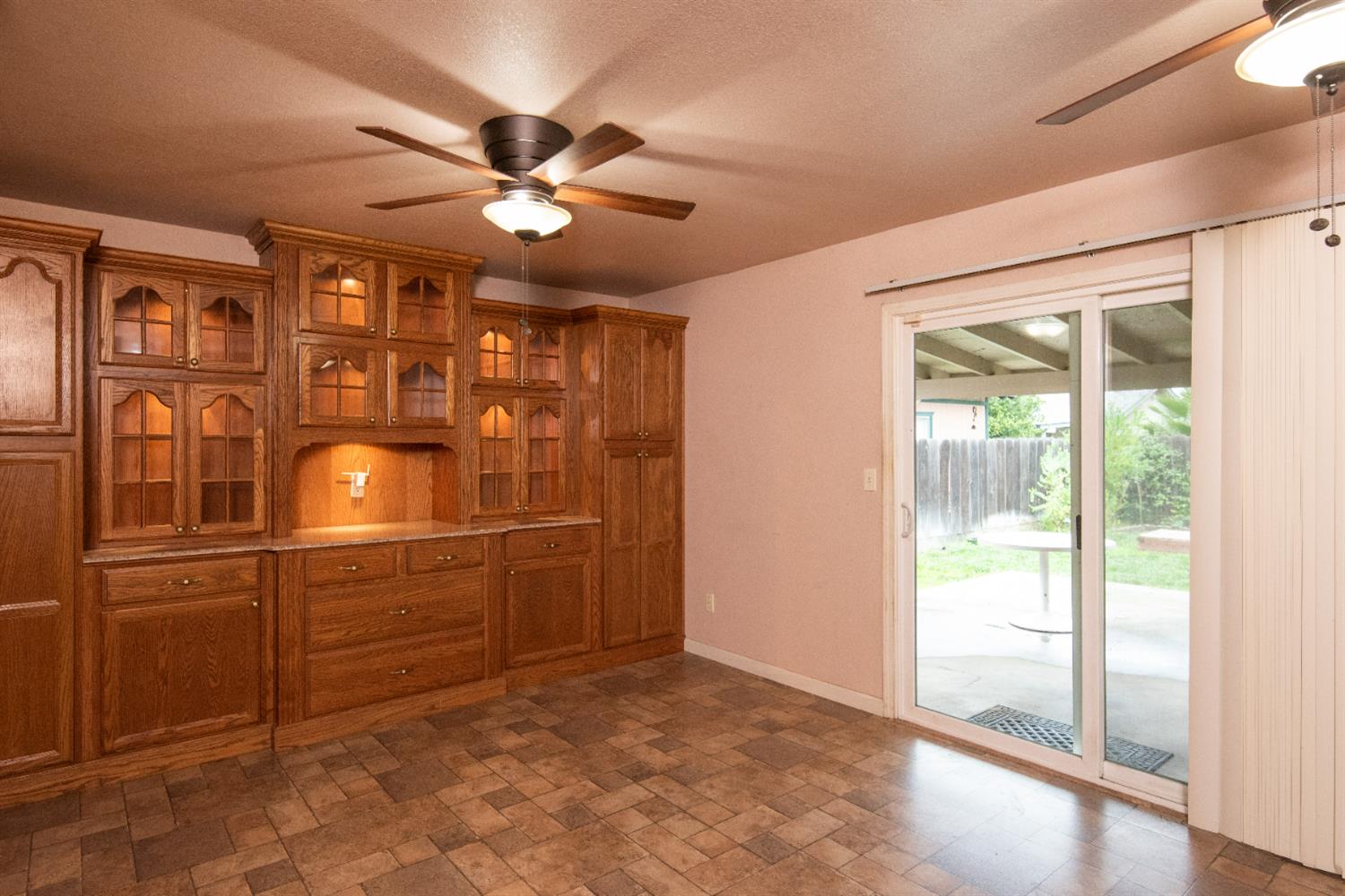 404 Trask Lane Modesto, CA 95354 - Photo 21 of 25 a view of a livingroom with furniture cabinet a ceiling fan and windows