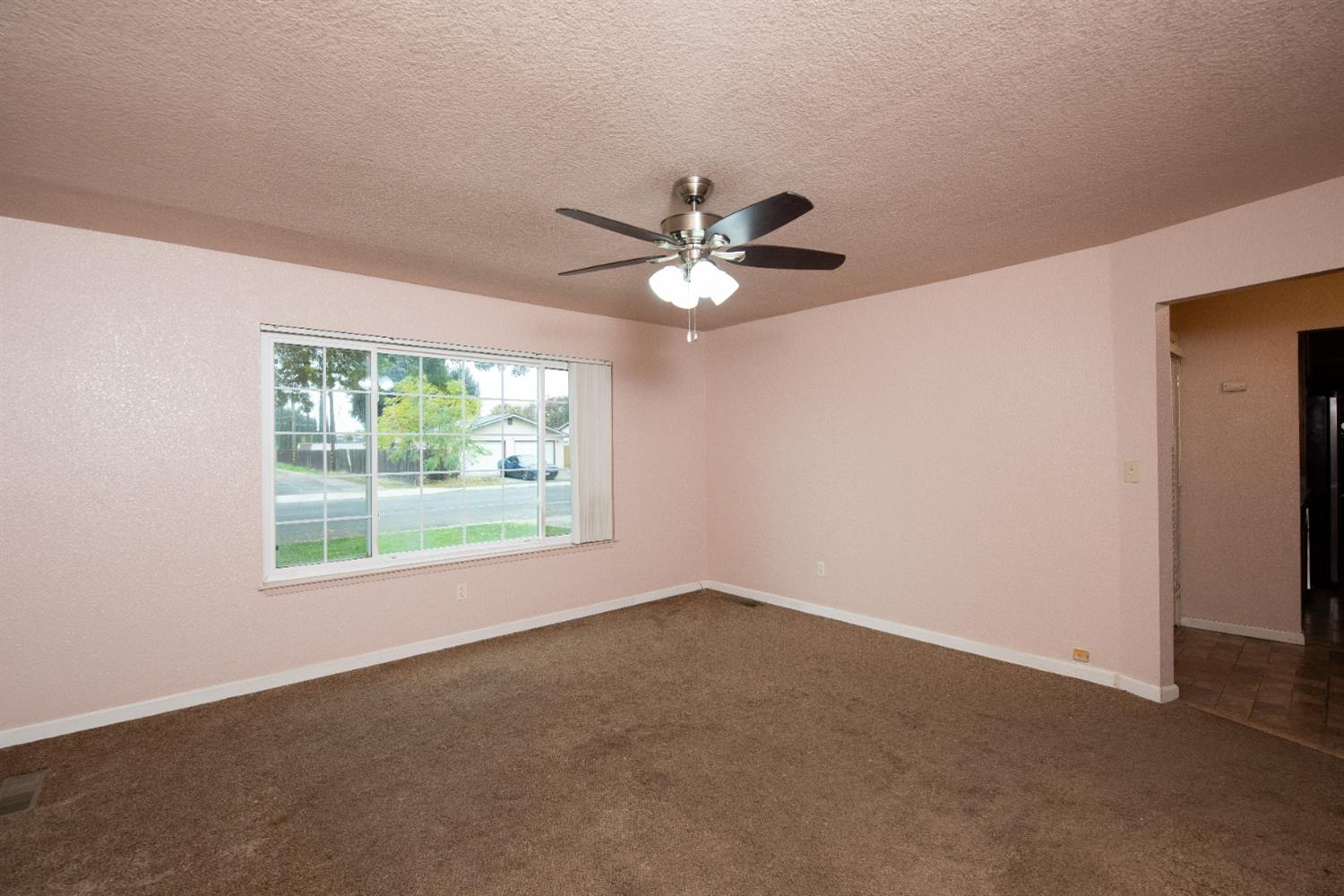 404 Trask Lane Modesto, CA 95354 - Photo 4 of 25 an empty room with a window and a fan