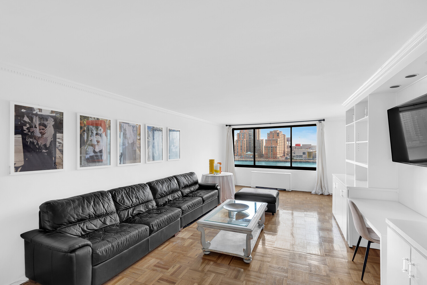 530 East 72nd Street, Unit 3F Manhattan, NY 10021 - Photo 3 of 16 a living room with furniture and a flat screen tv with wooden floor