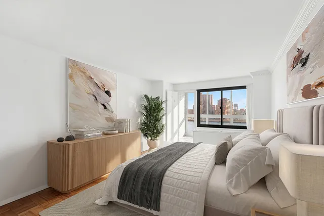 a bedroom with a bed and a potted plant on the dresser