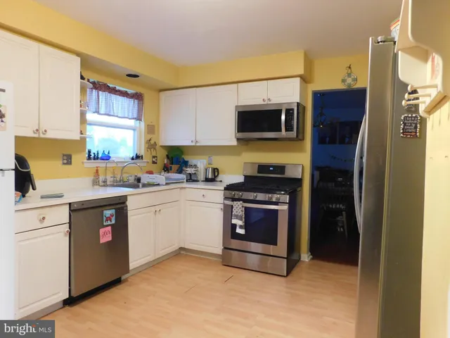 a kitchen with stainless steel appliances granite countertop a refrigerator a stove top oven a sink and dishwasher