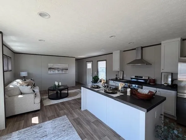 a kitchen with granite countertop a sink dishwasher stove and cabinets