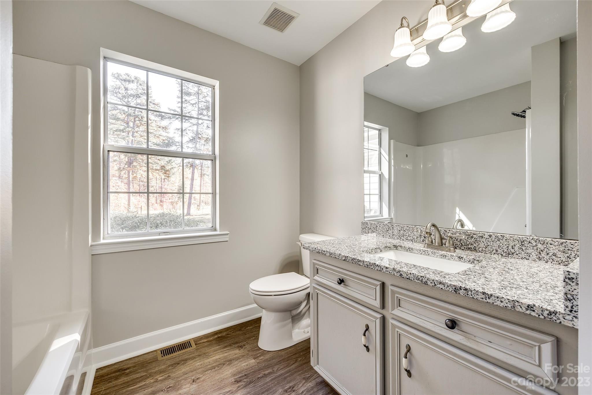 149 Airport Road Monroe, NC 28110 - Photo 28 of 41 a bathroom with a granite countertop toilet a sink a mirror and a window