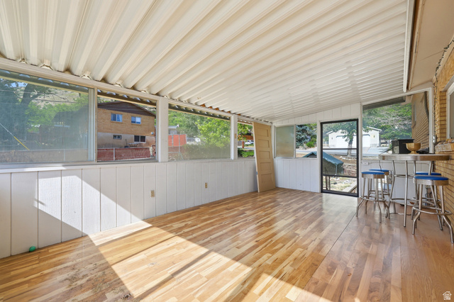 1486 3rd Street Ogden, UT 84404 - Photo 22 of 26 Enclosed sunroom featuring a paneled ceiling, wood-finish flooring, and white wainscoting