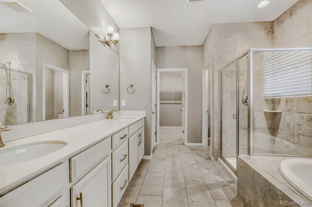 a spacious bathroom with a shower sink and a mirror