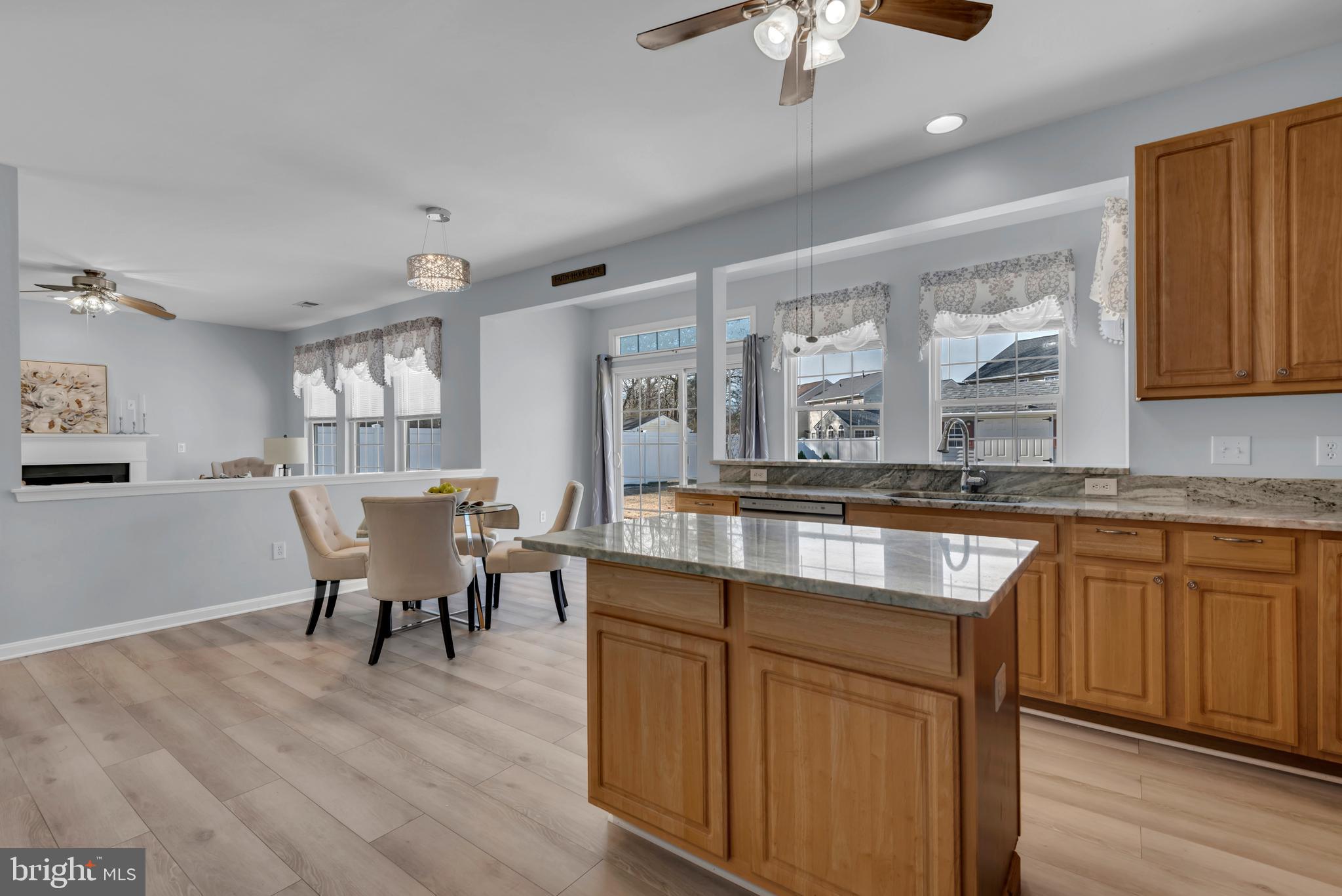 1104 Ruddy Duck Court Denton, MD 21629 - Photo 21 of 50 a large kitchen with cabinets a sink dishwasher a dining table and chairs with wooden floor