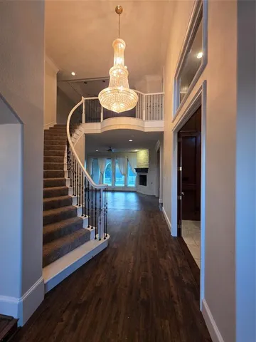 a view of staircase with a chandelier and wooden floor
