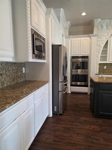 a kitchen with stainless steel appliances granite countertop a refrigerator and a stove top oven