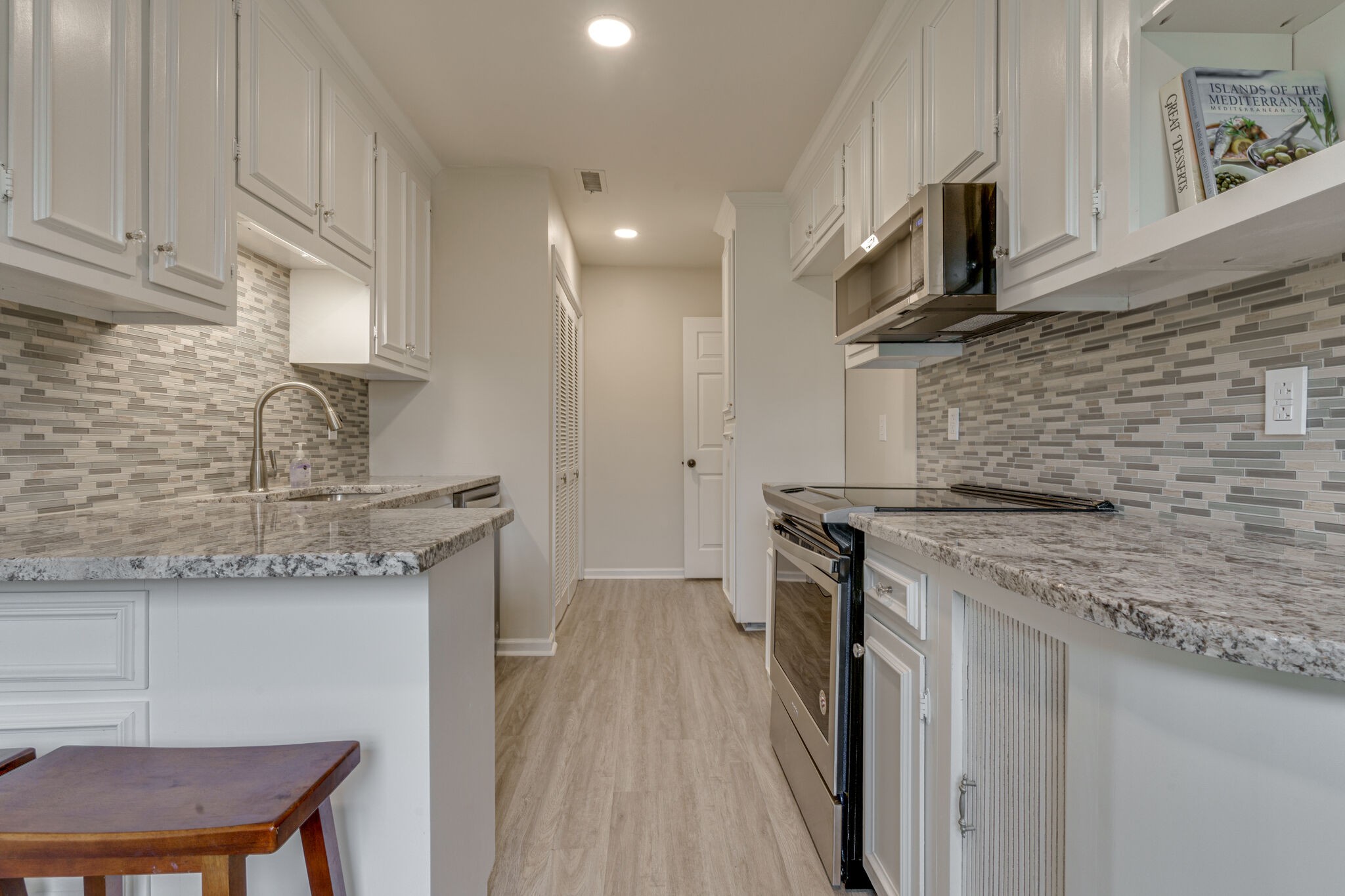 950 General George Patton Road Nashville, TN 37221 - Photo 18 of 34 a kitchen with stainless steel appliances granite countertop a sink a stove and a wooden cabinets