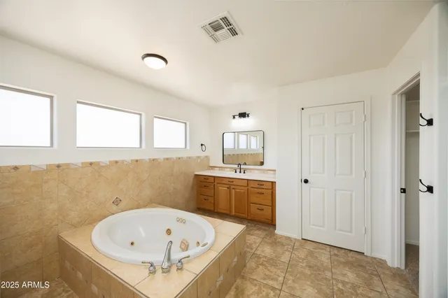 a spacious bathroom with a tub sink and mirror