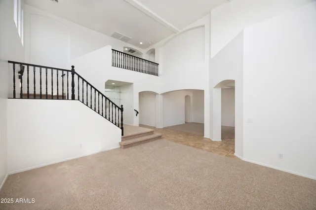 a view of a big room with wooden floor and windows