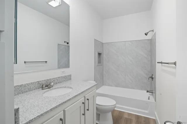 a bathroom with a granite countertop sink toilet and shower