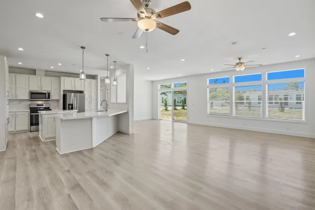 a view of kitchen with kitchen island stainless steel appliances sink and wooden floor