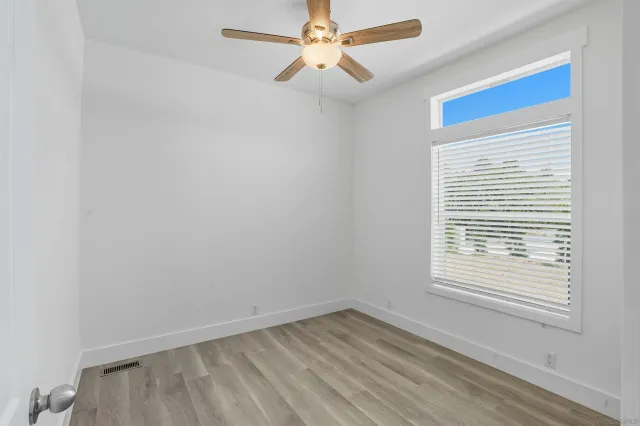 a view of an empty room with a window and a fan