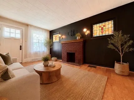 a living room with furniture a fireplace and a large window