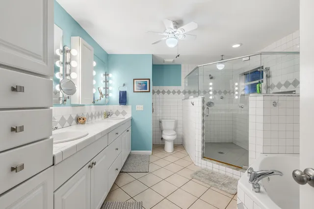 a bathroom with a double vanity sink mirror and shower