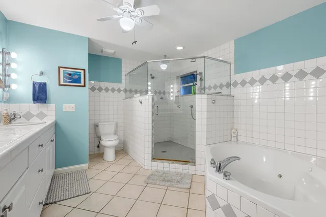 a bathroom with a granite countertop sink a toilet and shower