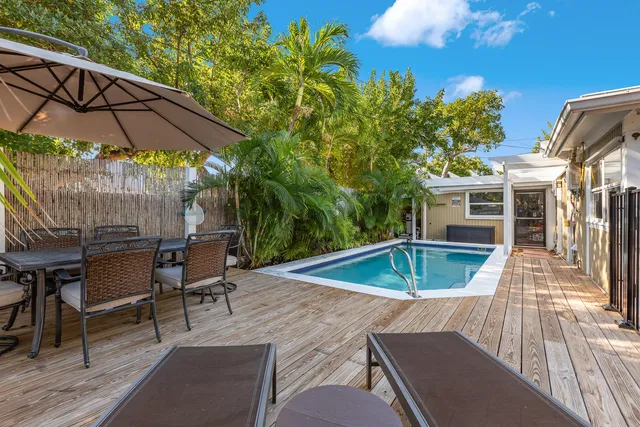 a view of a patio with table and chairs under an umbrella