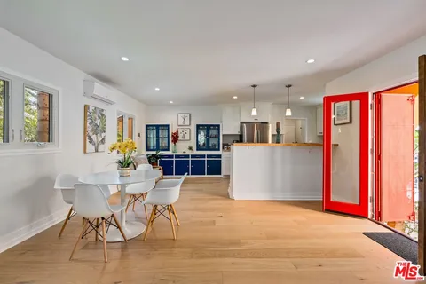 a kitchen with stainless steel appliances kitchen island granite countertop a refrigerator and a dining table