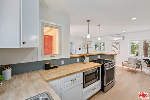 a kitchen with a refrigerator a sink a stove and chairs