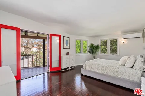 a bedroom with a large bed and a potted plant