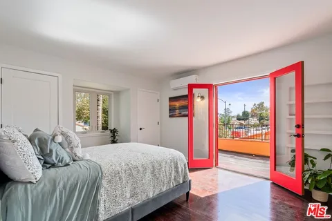 a bedroom with a balcony a bed and a dresser