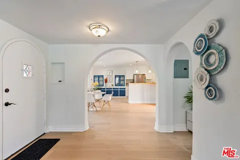 a living room with stainless steel appliances kitchen island granite countertop furniture and a wooden floor