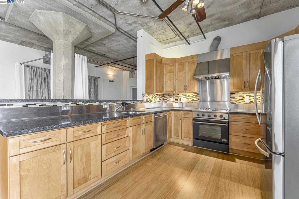 737 2nd Street, Unit 310 Oakland, CA 94607 - Photo 11 of 29 a large kitchen with cabinets wooden floor and stainless steel appliances