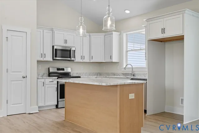 a kitchen with granite countertop white cabinets and a stove