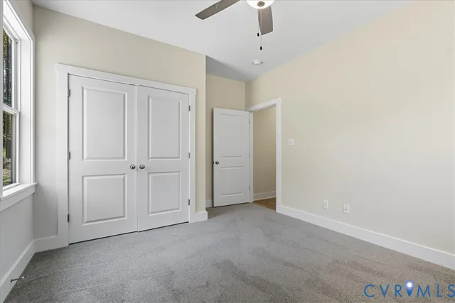 a view of an empty room with closet and windows
