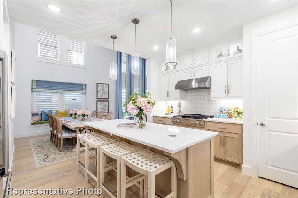 a kitchen with stainless steel appliances kitchen island granite countertop a sink a stove a refrigerator cabinets and chairs