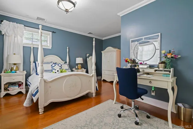 a bedroom with a bed window chair and a potted plant