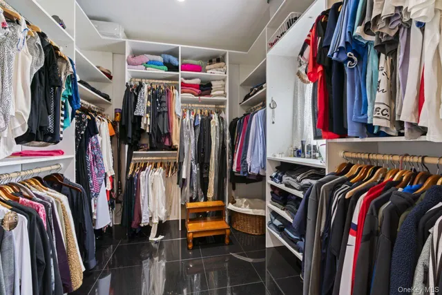 a view of walk in closet with clothes and shoes
