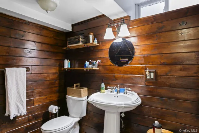 a bathroom with a sink toilet and a mirror